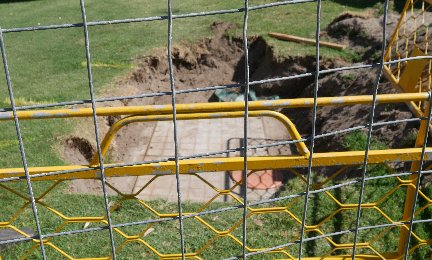 Trench showing manhole cover entrance to cable connection, Dunninham Reserve